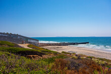 The US/Mexico Border Fence Going Into The Pacific Ocean. The Large Fence Separates Mexico And California.