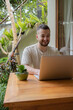 © Julija - Young man using a laptop computer in a garden . business, study, freelance