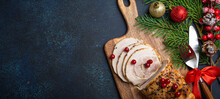 Christmas Baked Ham Sliced With Red Berries And Festive Decorations On Wooden Cutting Board, Dark Rustic Background From Above. Christmas And New Year Holiday Dinner With Baked Pork, Space For Text