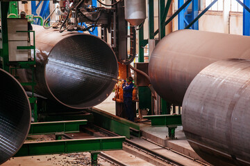 Wall Mural - Worker cleans welded seam on steel pipe using grinding machine