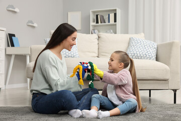 Wall Mural - Happy mother and daughter playing with funny sock puppets together at home