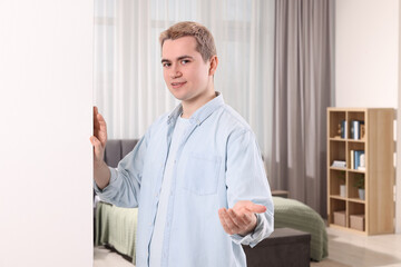 Wall Mural - Happy man inviting to come in room