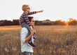 © kieferpix - Father and son bonding in nature walking through meadow at sunset