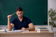 © Elnur - Young male teacher sitting in the classroom