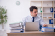 © Elnur - Young male employee and too much work in the office