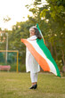 © Niks Ads - Indian senior woman waving tricolor cloth or odhani. celebrate national festival.