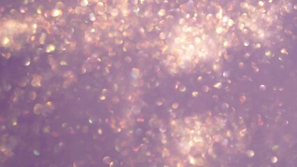 Wall Mural - abstract motion of gold bokeh lights on purple background. blurry gold particles in liquid float and