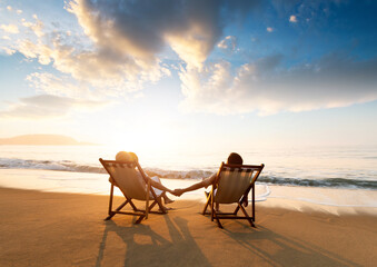 young couple sunbathing on beach chair