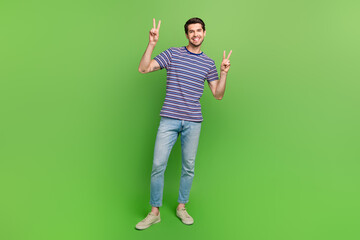 Poster - Full length photo of cool cheerful man dressed striped t-shirt smiling showing two v-signs isolated green color background