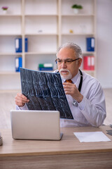 Old male doctor radiologist working in the clinic