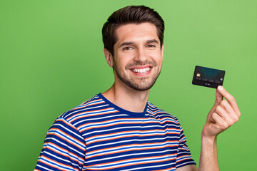 Wall Mural - Portrait photo of young marketing promoter advert plastic debit card payment receive salary worldwide isolated on green color background