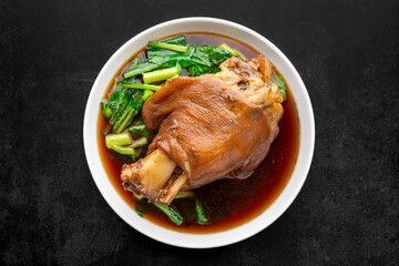 Kha Moo Pa Lo, Thai street food, brown Chinese stewed pork knuckle leg in sweet brown sauce on dark tone texture background, top view shot, flat lay