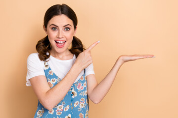 Wall Mural - Photo of impressed overjoyed girl wear blue overall indicating at palm demonstrate product empty space isolated on pastel color background