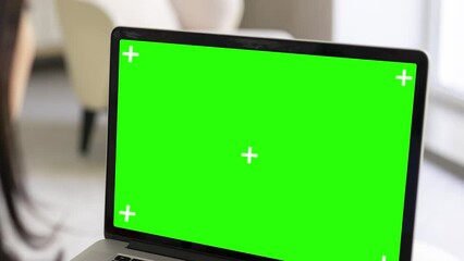 4K Dolly in short. Over the shoulder of a business woman working in an office on a laptop on her feet, looking at a green screen. Office man using laptop computer with laptop green screen.