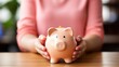 © AI BLONDY - Close-up of a woman holding a piggy bank in her hands
