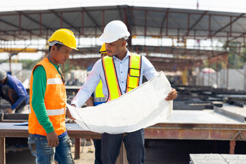 Wall Mural - Professional Engineer Team working. Young architect Engineering and asian worker in safety hardhat and  looking at blueprint at industrial Heavy Manufacturing Factory. Prefabricated concrete walls