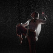© Ulia Koltyrina - Dancing in the rain. A young woman in wet clothes dancing among water droplets, photo in the aqua studio. beautiful silhouette, model in a white shirt