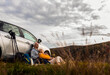 © Zoran Zeremski - Senior couple sitting against the car, resting after hiking in countryside.