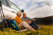 © Zoran Zeremski - Senior couple sitting against the car, resting after hiking in countryside.