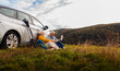 © Zoran Zeremski - Senior couple sitting against the car, resting after hiking in countryside.