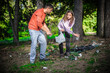 © guruXOX - Young couple collect garbage thrown in nature park. Protection, maintenance and preserve of the eco green environmental. Trash Impacts the environment