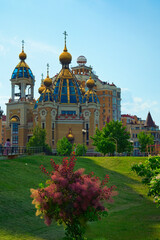 Wall Mural - Picturesque cityscape view of modern orthodox church. Obolon neighborhood in Kyiv, Ukraine. Church of the Nativity of Christ with glass domes against blue sky. Concept of modern architecture