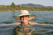 © Cristina - portrait of woman bathing with bikini, chubby white-skinned person in her forties with straw hat with wide eave, natural landscape