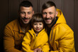 © AdrianGomezFoto - Portrait of couple of gay men posing smiling with their son. Adoption concept