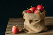 apples in a bag and on a wooden table