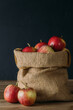apples in a bag and on a wooden table