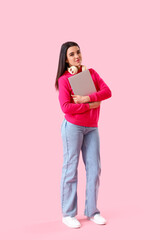 Wall Mural - Young female programmer with laptop on pink background