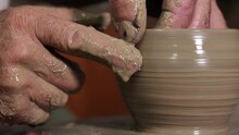 Close-up Of The Hand Of A Potter Who Makes A Jug From Clay On A Potter's Wheel. An Elderly Man Creates Craft Pottery In His Own Workshop Using The Traditional Method.