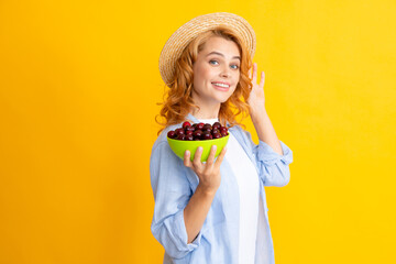 Wall Mural - Portrait of beauty redhed woman with cherries on yellow isolated background.