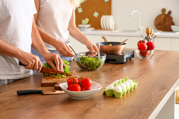 Mature couple cooking in kitchen, closeup