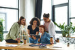 © LIGHTFIELD STUDIOS - cheerful multiracial woman showing notebook to positive multicultural members of women interest club near table with paper cups of takeaway drinks, spending time in friendly diverse community
