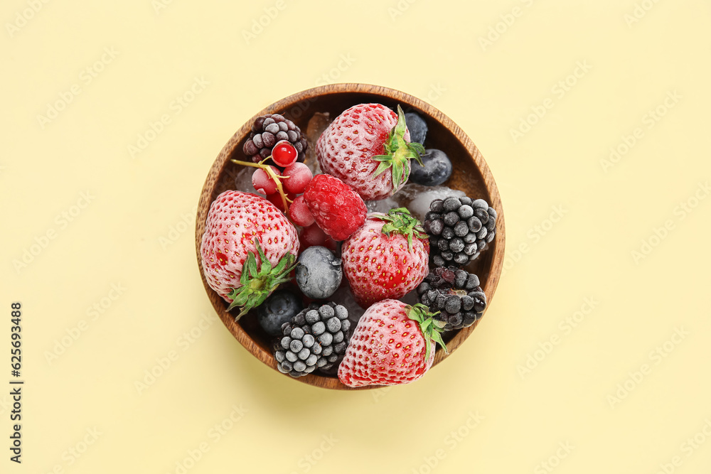 Bowl of frozen berries on yellow background