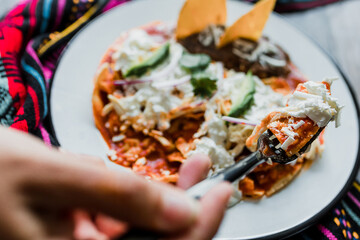 Sticker - Mexican chilaquiles food with spicy red sauce, chicken and avocado traditional breakfast in Mexico Latin America