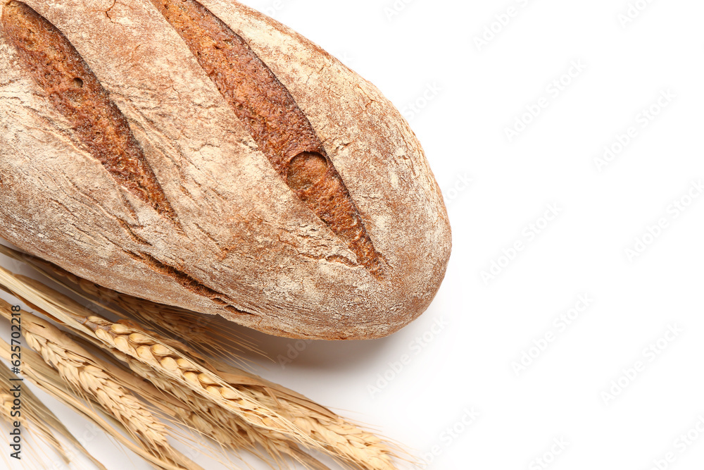 Loaf of fresh rye bread and wheat ears isolated on white background