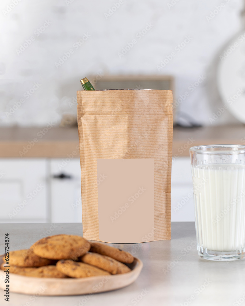 A brown kraft paper bag with a label layout on the kitchen table with a ...