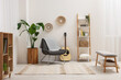 Spring atmosphere. Stylish room interior with comfortable chair, houseplant and shelving unit