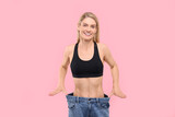 Fototapeta Panele - Slim woman wearing big jeans on pink background. Weight loss