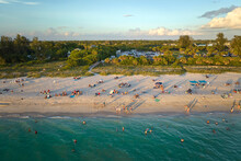 High Angle View Of Crowded Nokomis Beach In Sarasota County, USA. Many People Enjoing Vacations Time Swimming In Ocean Water And Relaxing On Warm Florida Sun At Sundown