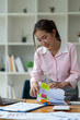 © Phimwilai - Asian businesswoman working in piles of paper files Documents in the meeting to search and review the various work folders at the desk to record information. management concept