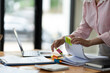 © Phimwilai - Asian businesswoman working in piles of paper files Documents in the meeting to search and review the various work folders at the desk to record information. management concept