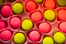 Pink And Yellow Confections In Pink Wrappers Arranged On A Table