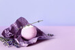 Crumpled paper with bath bomb with lavender flowers on color background