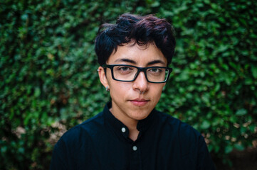 Close-up view of a transgender person posing on natural background.