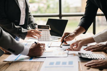 Wall Mural - Business documents on office table with smart phone and calculator digital tablet and graph business with social network diagram and two colleagues discussing data working in the office..