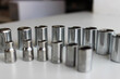 © AnyVIDStudio - Ratchet Drive Sockets For Hex Nuts Arranged By Size On White Workbench