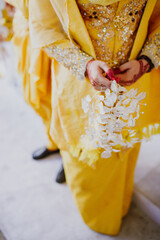 Wall Mural - Bride holding gentle wedding bouquet. Malay wedding ceremony. Selective focus.